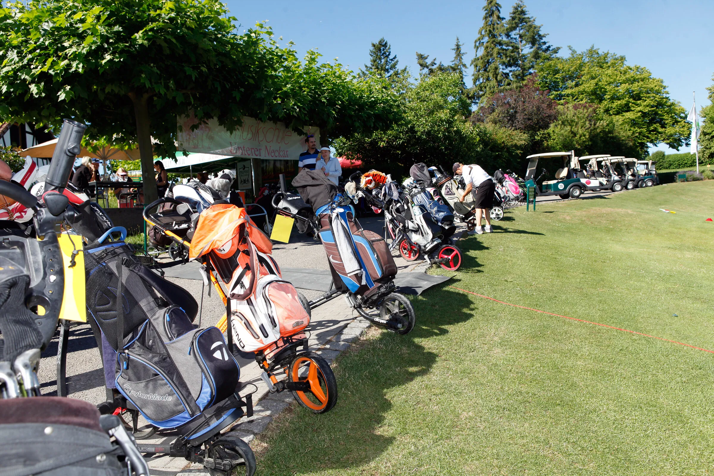 Aufstellung vor dem Start: Golfbags und Trolleys am Clubhaus.