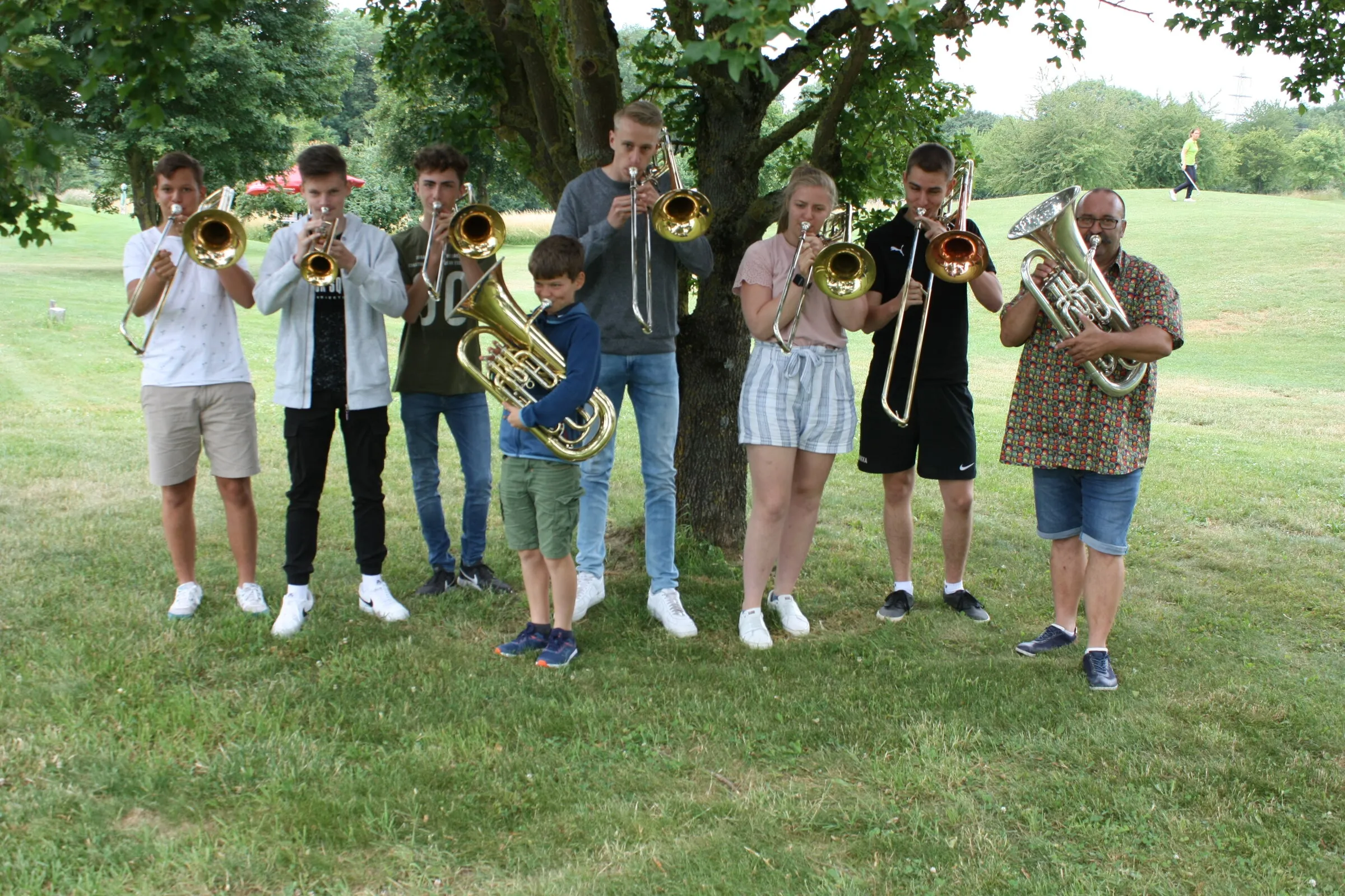 Blechbläser der Musikschule unter einem Baum auf dem Platz.
