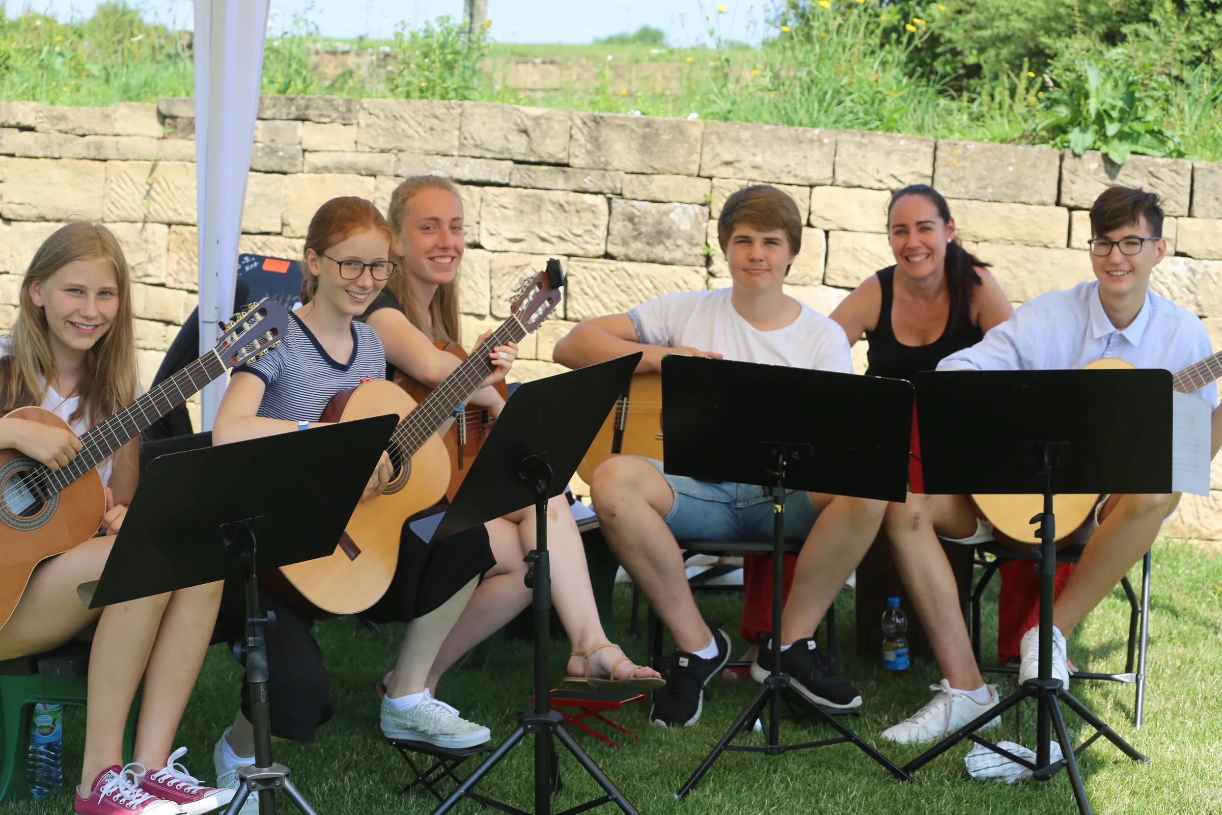Gitarrenensemble der Musikschule an der Natursteinmauer.