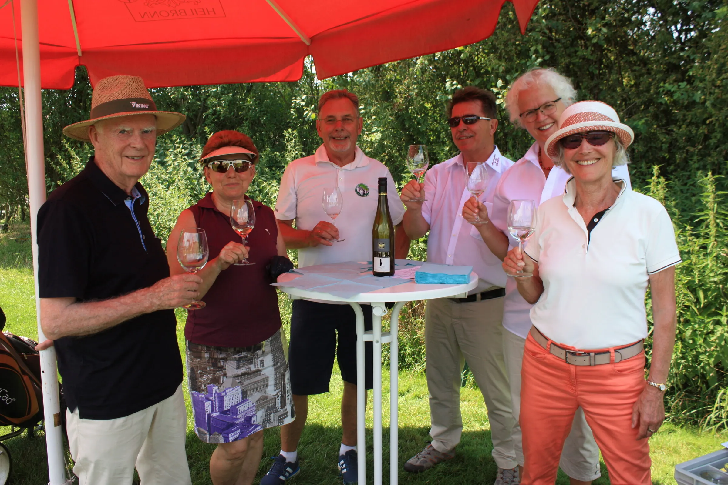 Weinprobe unter dem roten Sonnenschirm.