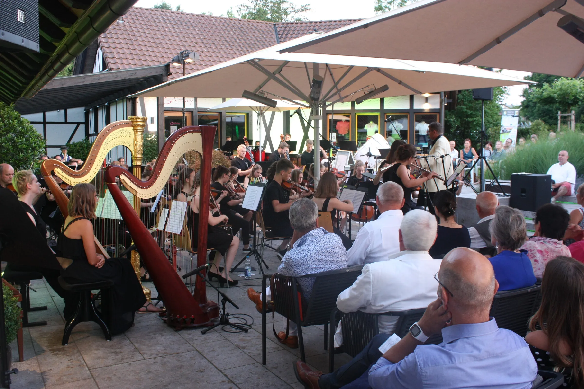 Sommernachtskonzert: Harfen und Orchester unter den Schirmen der Clubhaus-Terrasse.