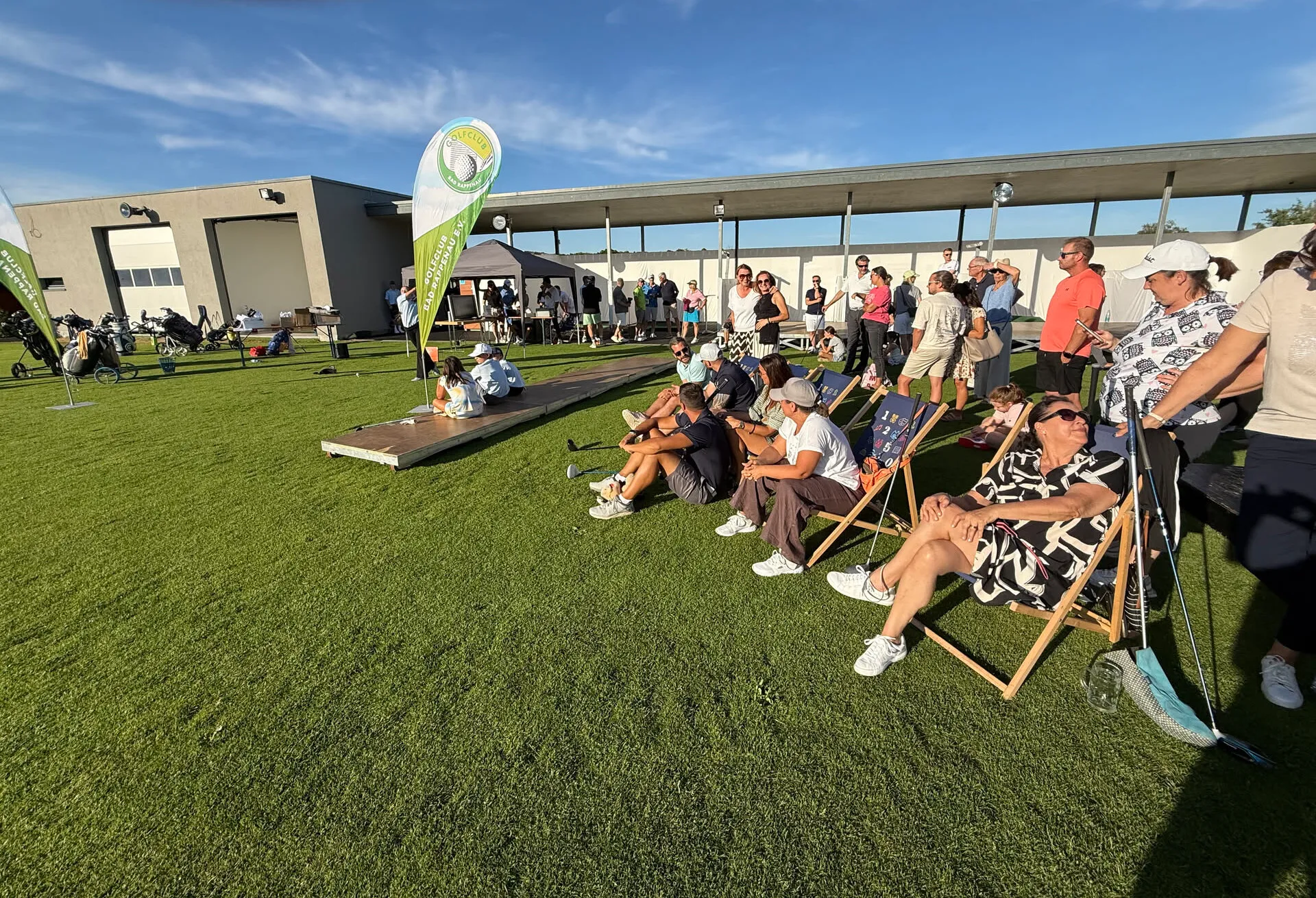 Gäste in Liegestühlen an der Driving Range